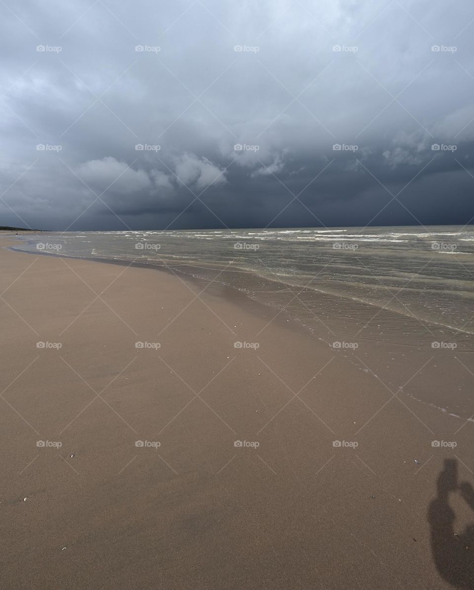 My shadow is taking this picture of rain clouds