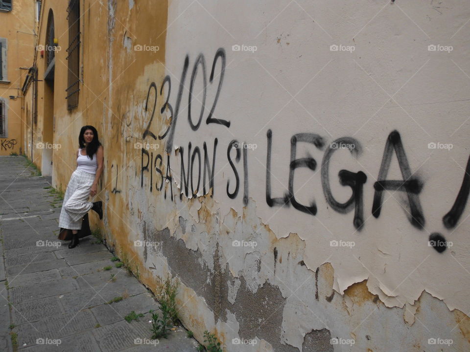italian lady on streets of pisa with graffiti