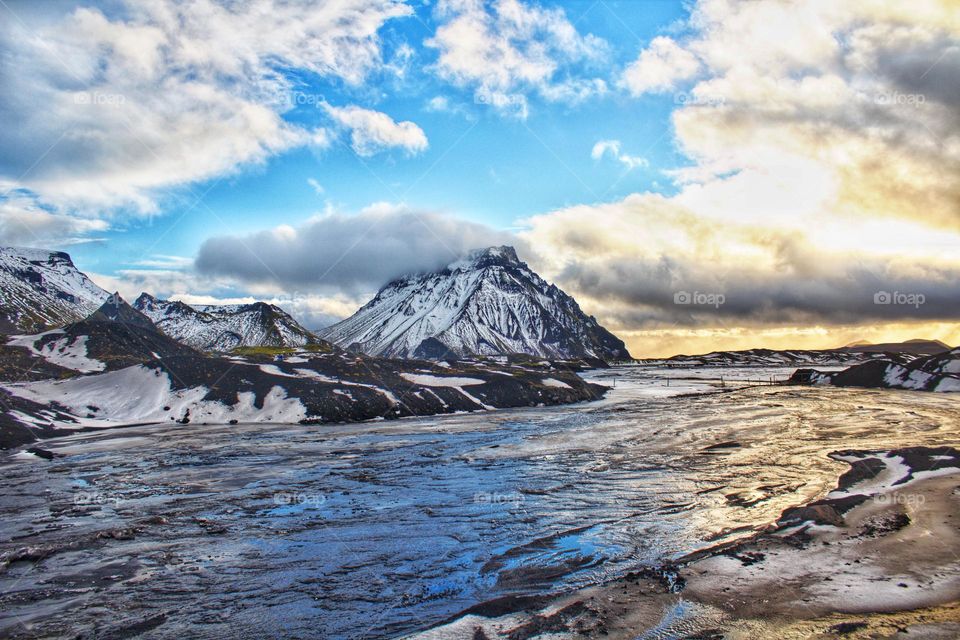 A shot of blue: Snow covered mountains and water on Mýrdalsjökull glacier in Iceland.