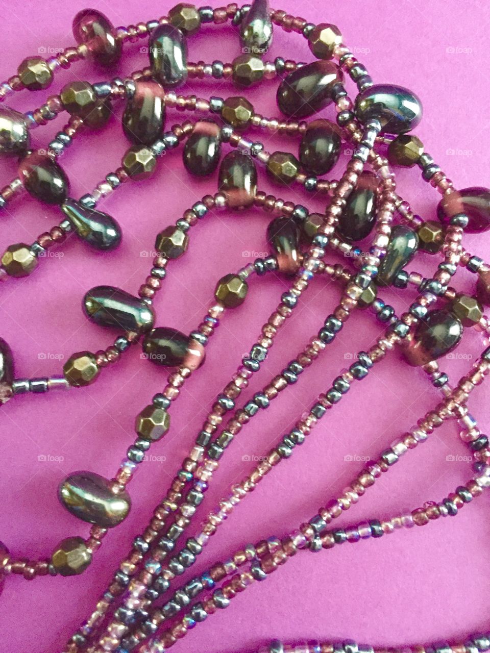 Beads necklace on pink background