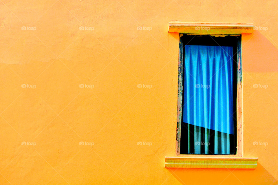 Orange wall and blue curtain