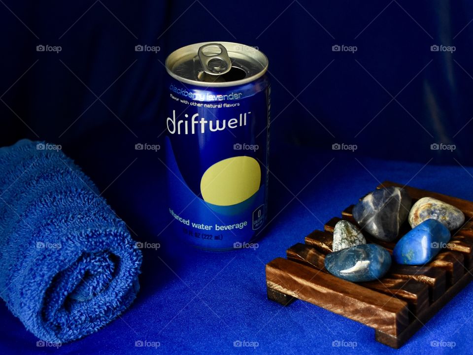 Driftwell still life with blue background and blue cloth and blue stones 