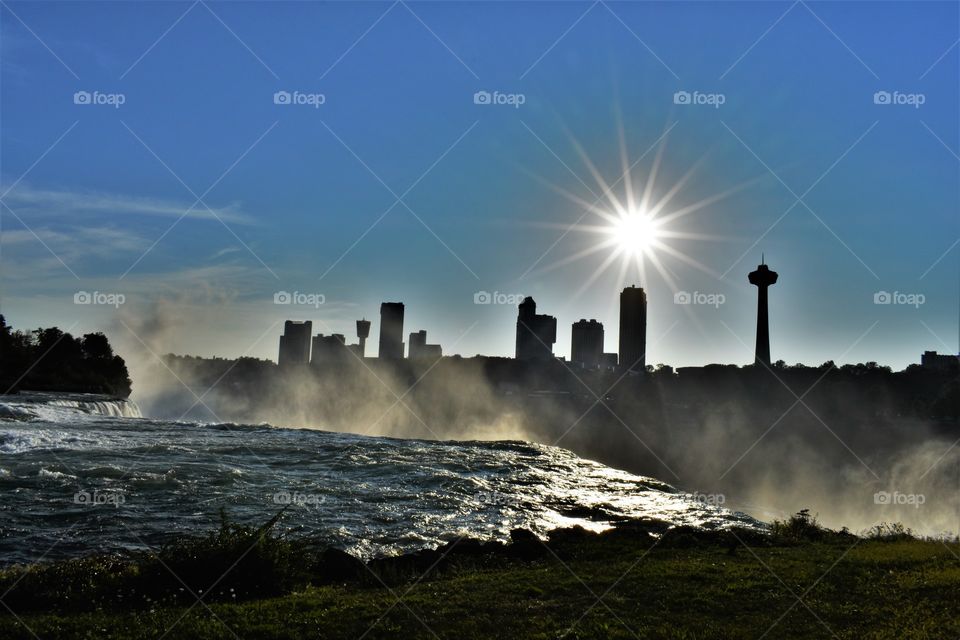 This photo is taken over Niagara falls looking across the border from the USA to Canada as the sun sets over the city.