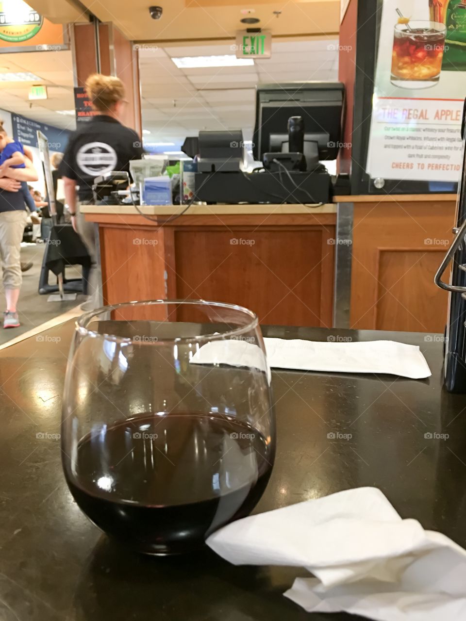 Airport bar, red wine in glass foreground