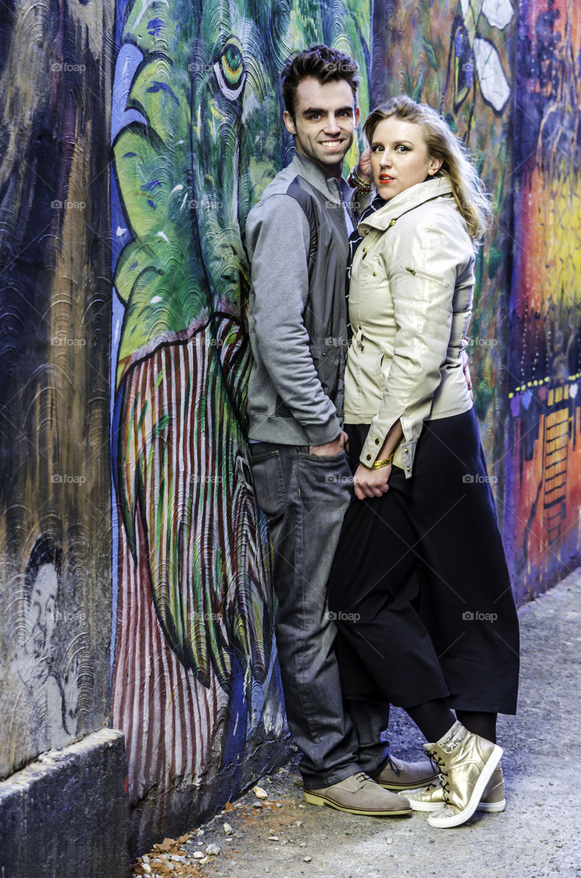 Portrait of young couple leaning on wall