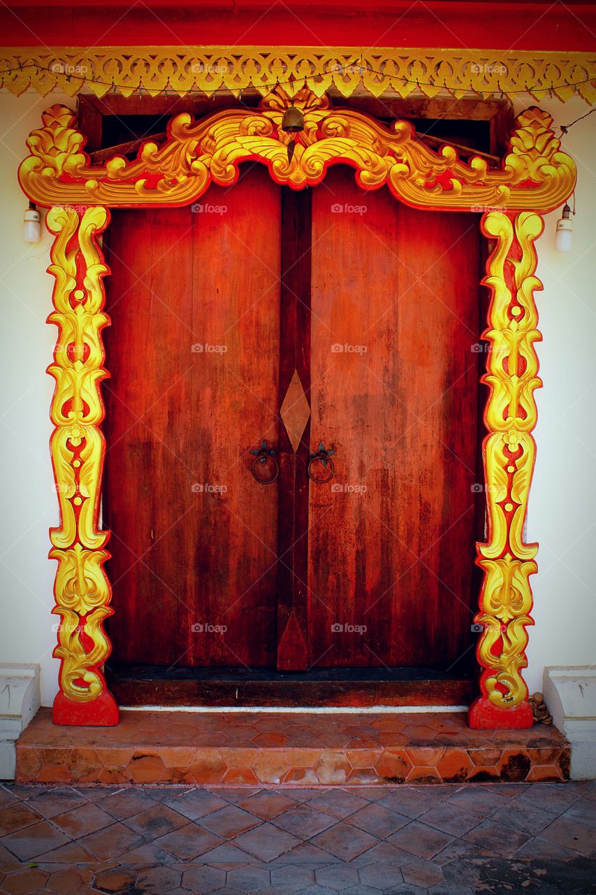 Old wooden door with the art in Thai style. At the temple Thailand.