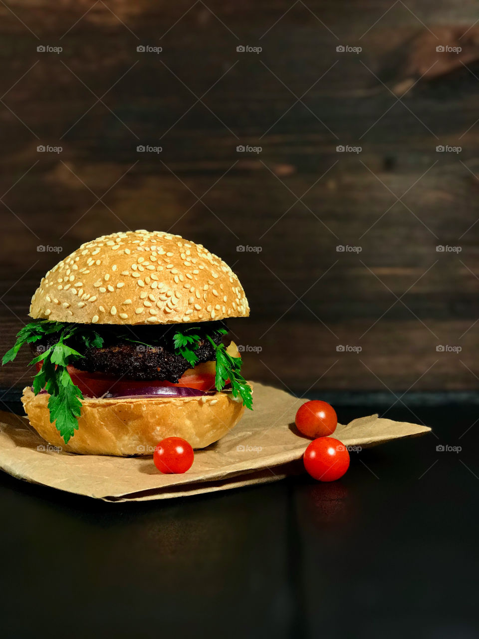 American burger with vegetables on wooden board 