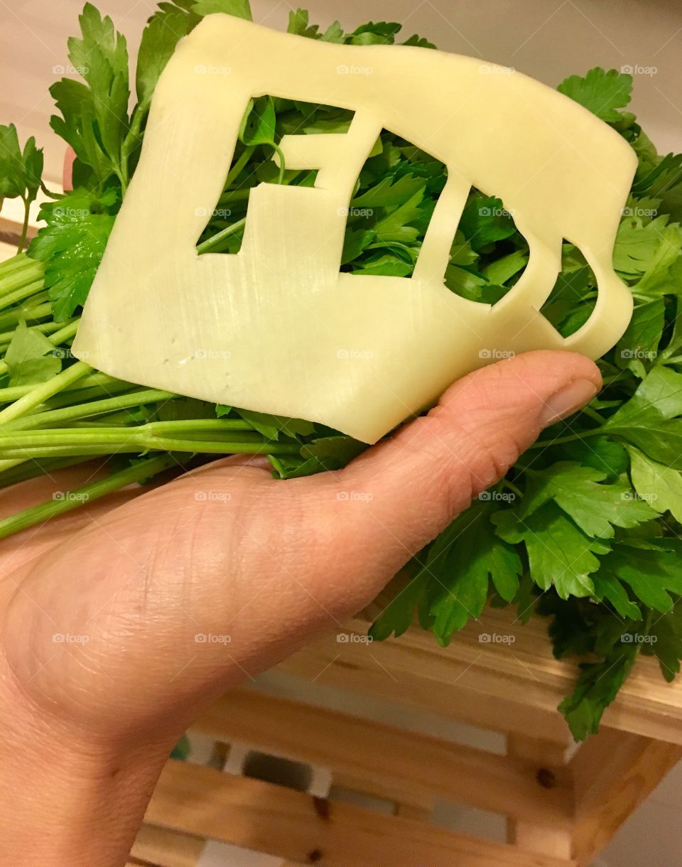 Yellow cheese and parsley in hand