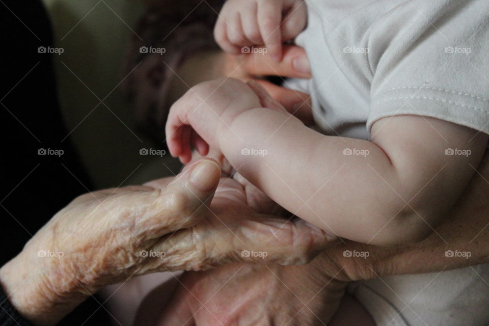 A great, great grandmother holds the hand of her great, great grandchild showing five generations