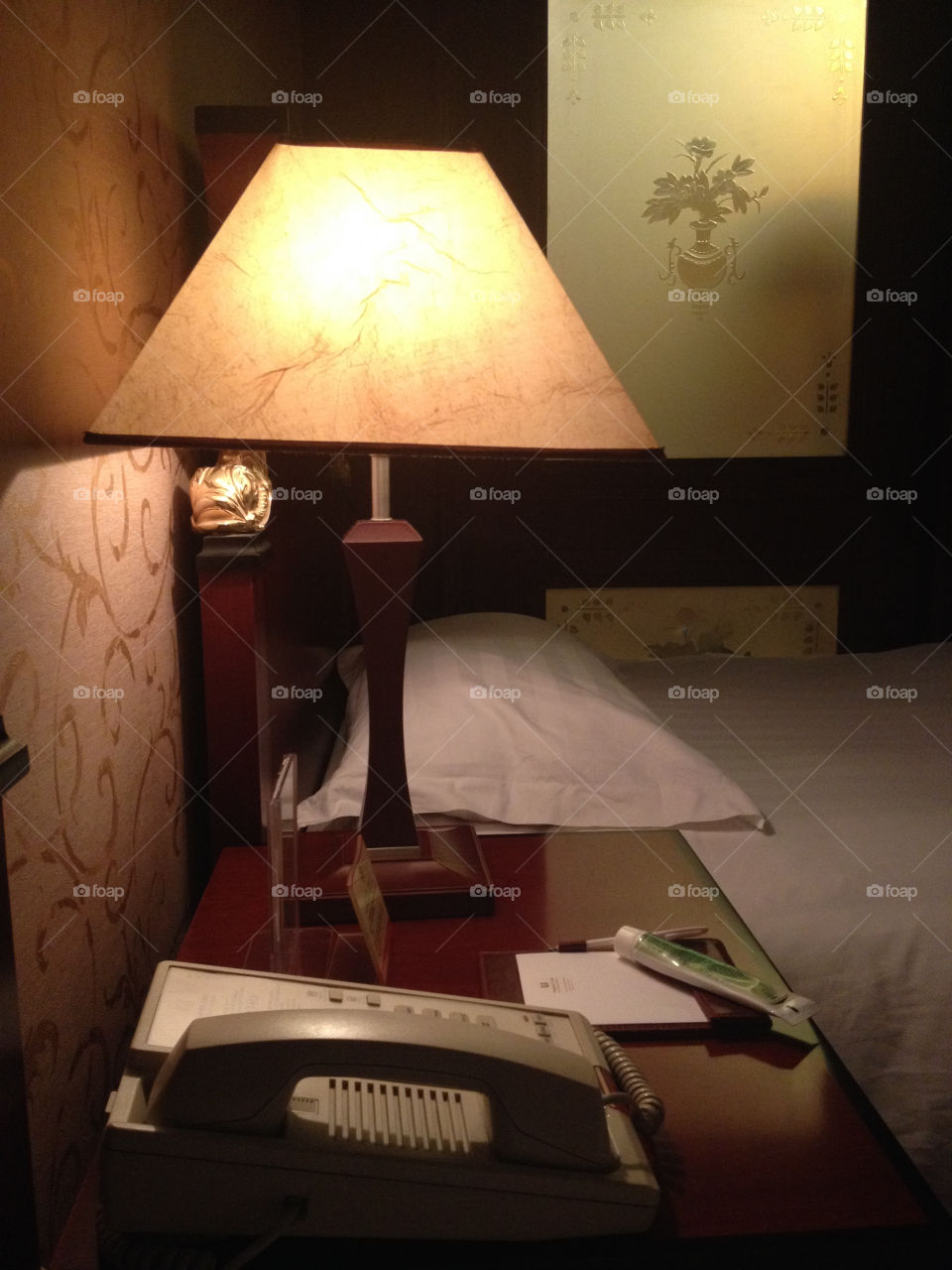 A lightning lamp in a hotel room near bed