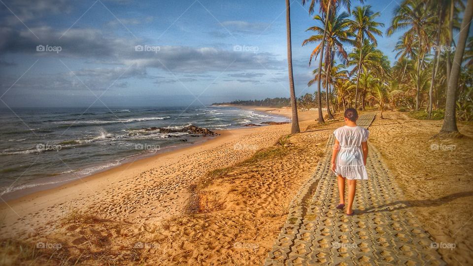 criança passeando na praia