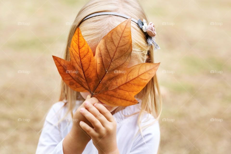 Girl holding big maple leaf