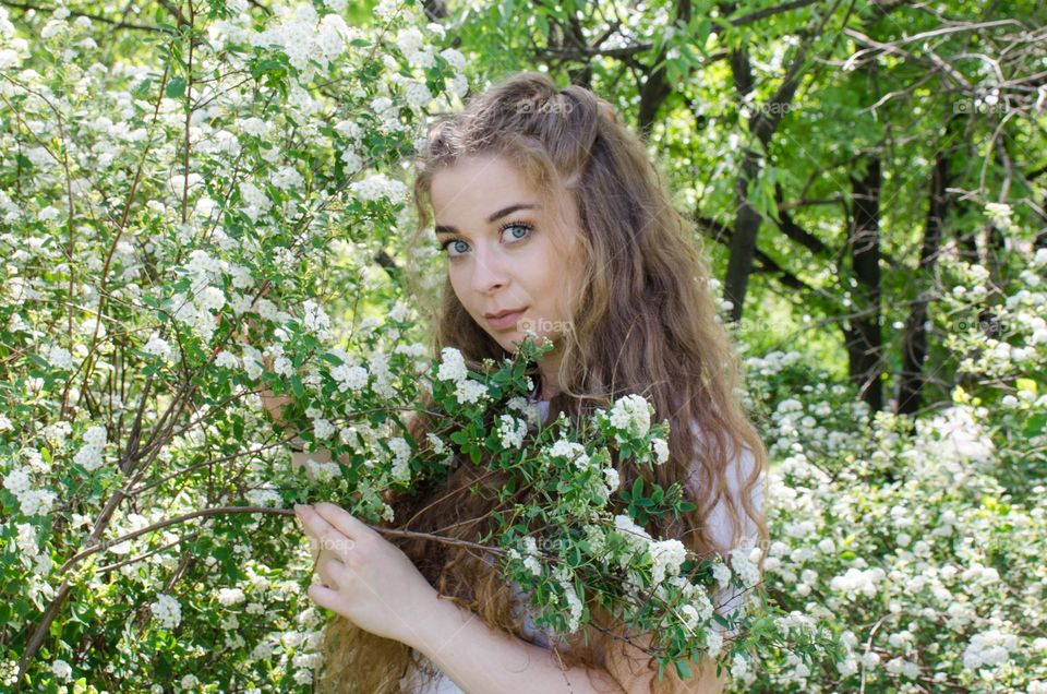 Portrait of Beautiful Young Girl on Flowers Background