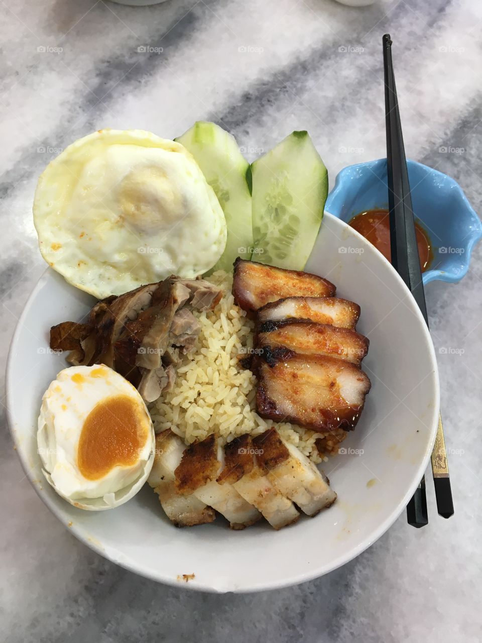 Rice with roast pork, braised pork and roast duck with fried and salted eggs
