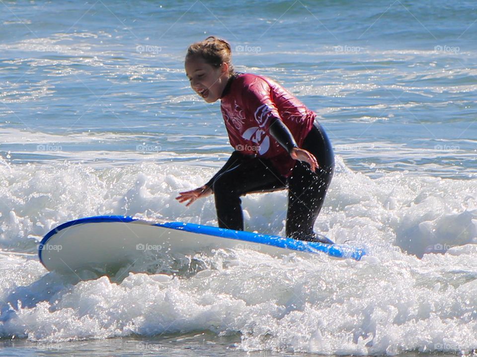A closeup of my 9 yr old daughter surfing like an old pro! She sliced that wave and rode it in on her first run! Her hair is still dry! So very proud of her accomplishment!