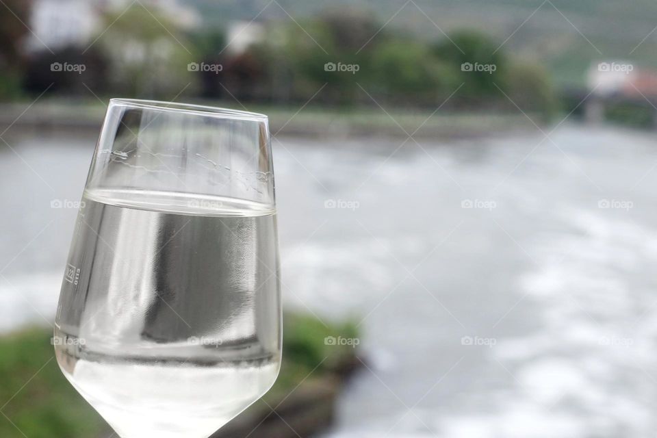 Close-up of a glass with drinking water on a river in the city