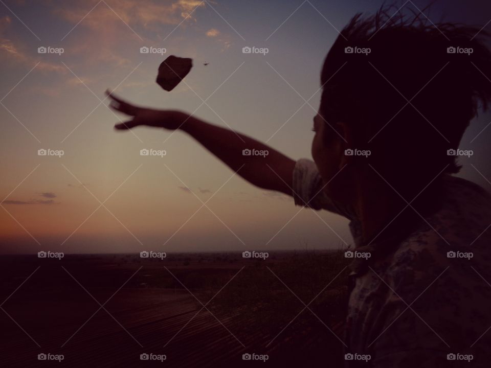 Rear view of a Person throwing rock