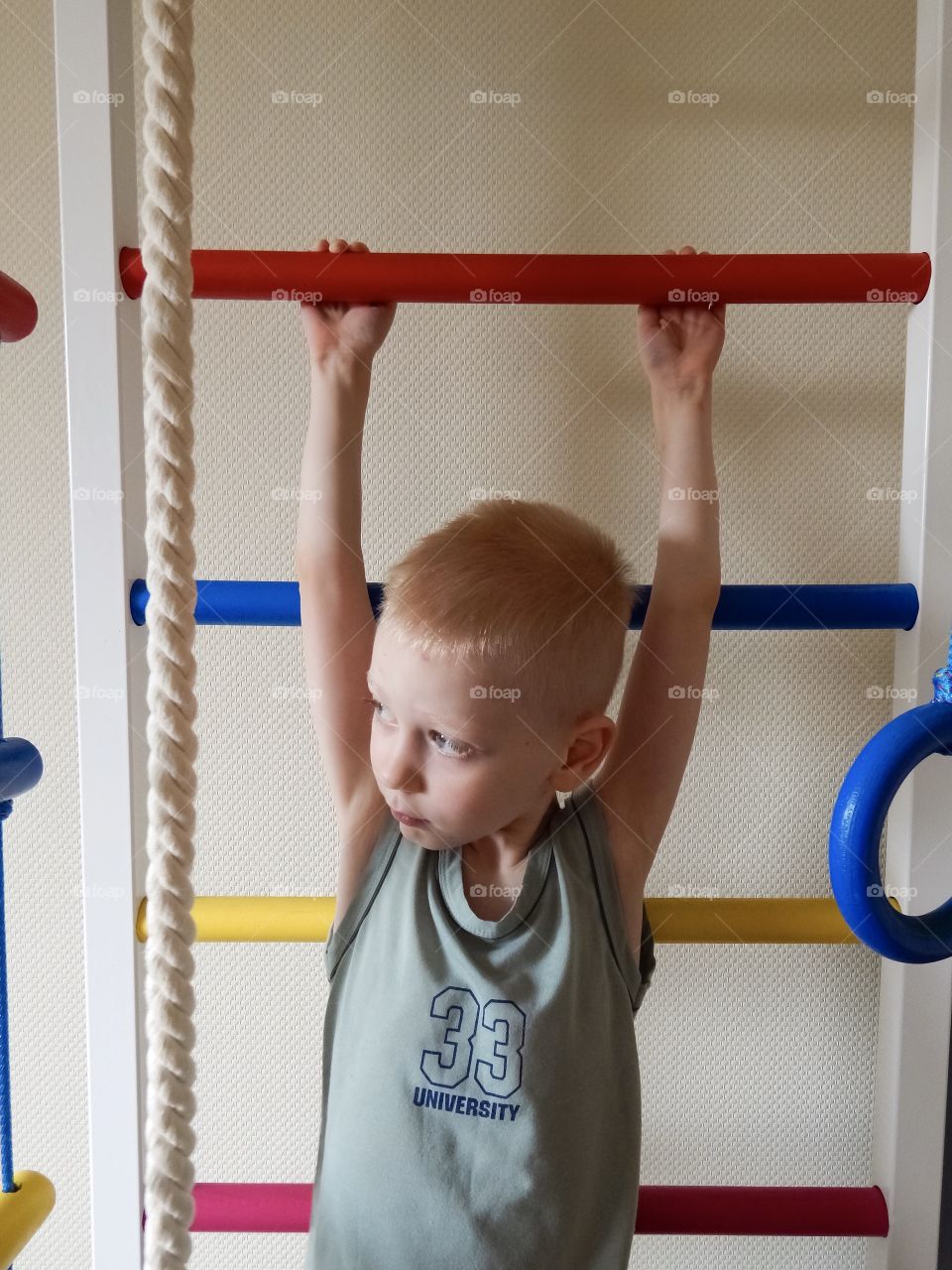 boy goes in for sports on a ladder, home work out