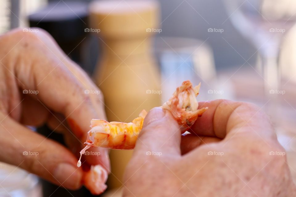 Eating prawns seafood, mature male hands holding cooked fresh prawns closeup concept dining, cooking, cuisine, seafood, copy and text space