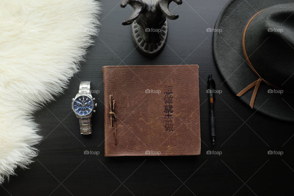 Leather journal with Chinese writing sitting on a desk. 