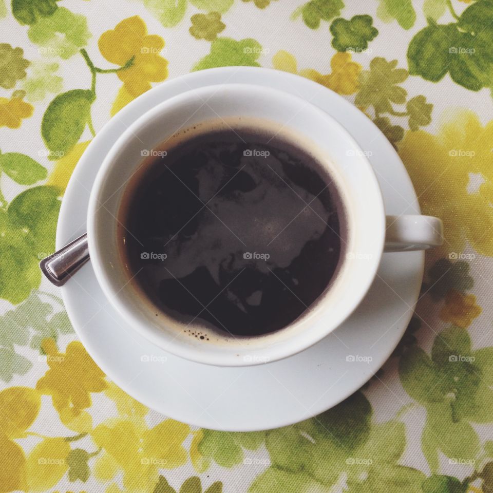 Coffee. Single cup of black coffee on a retro tablecloth