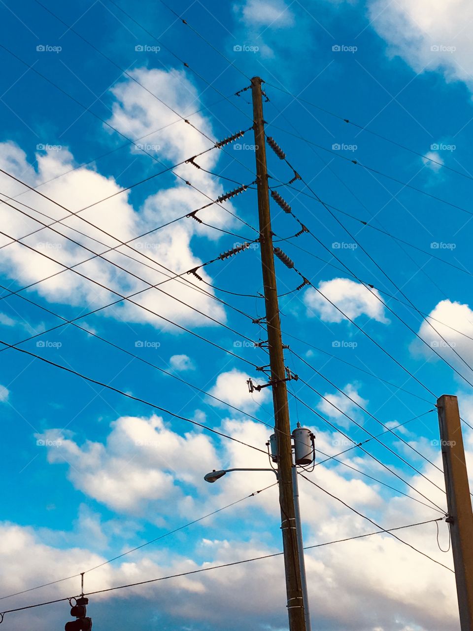Power lines in the clouded blue sky