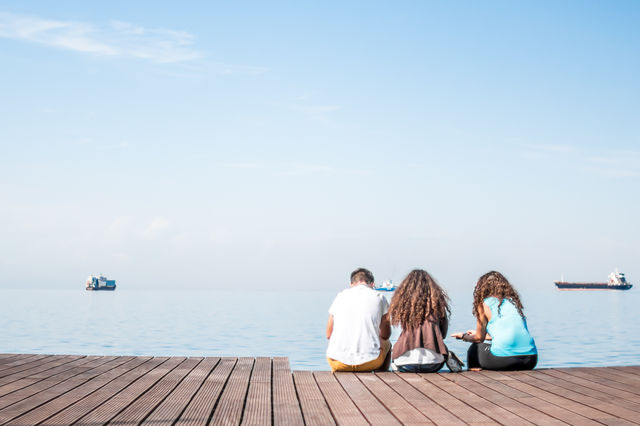 Friends Sitting On Wooden Dock
