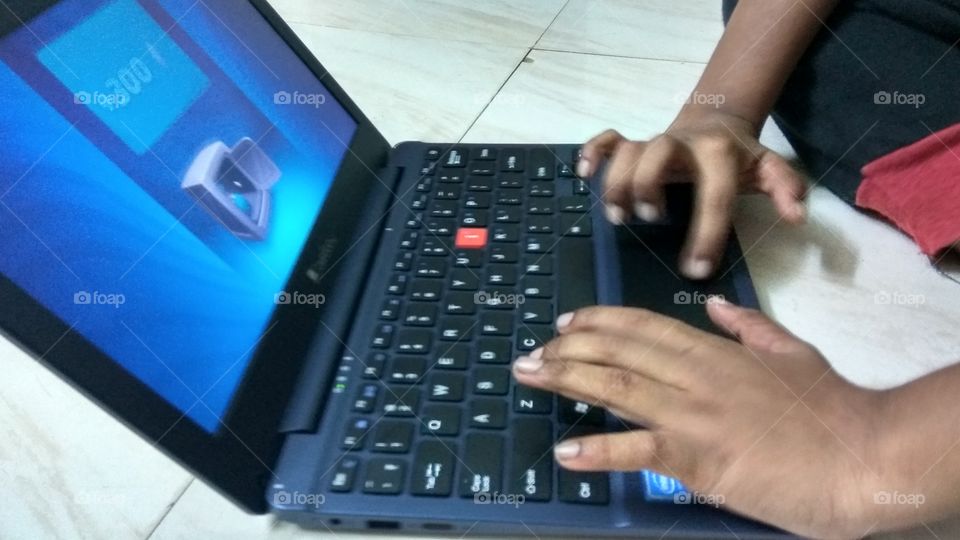 child operating laptop playing games