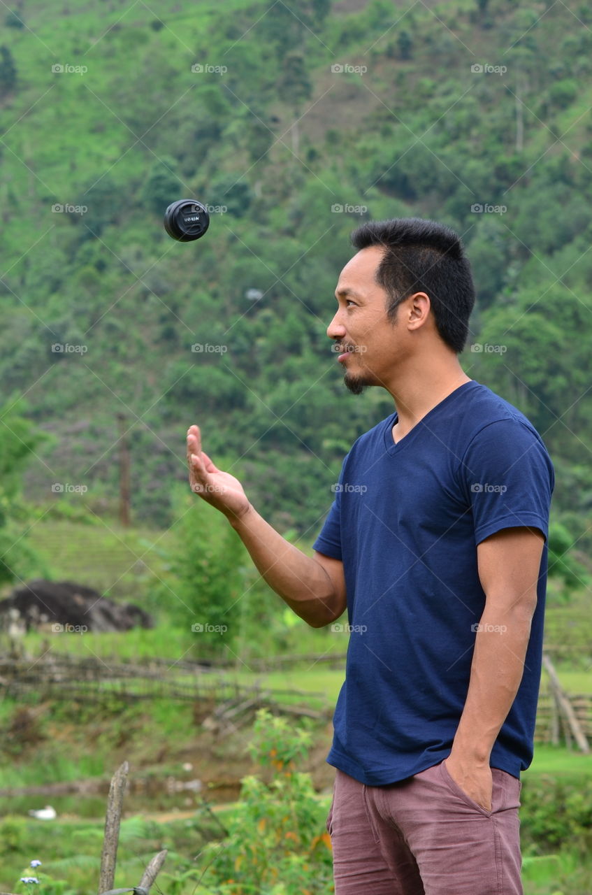 Asian man catching camera lens