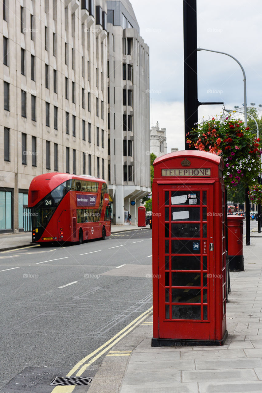 Red London bus driving in central London.