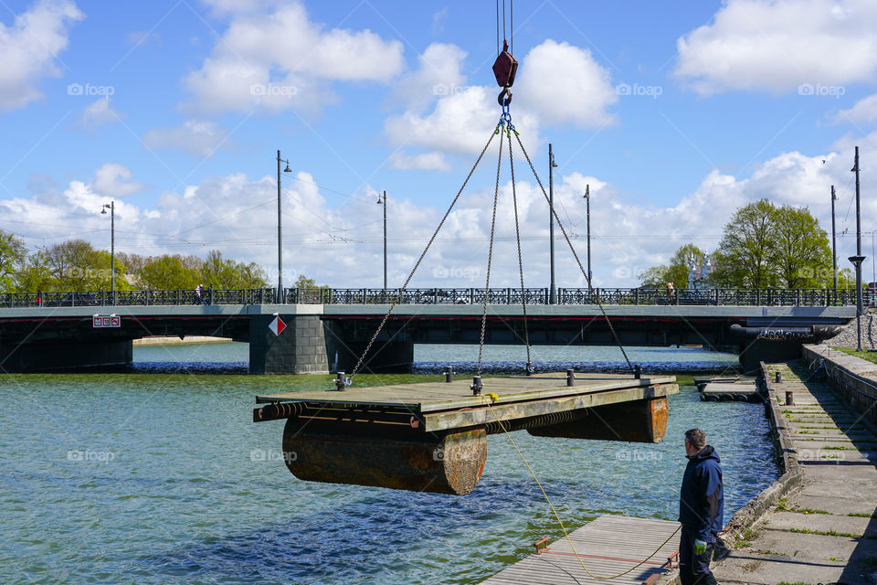 placing a big floating marina ponton in the water with the help of a crane