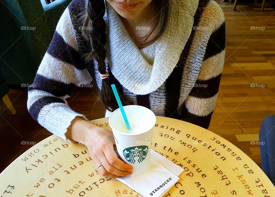 A girl in the cafe drinking coffee