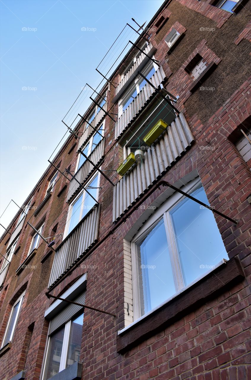 front of an old house with clinker bricks and reflections of the sky in the windows