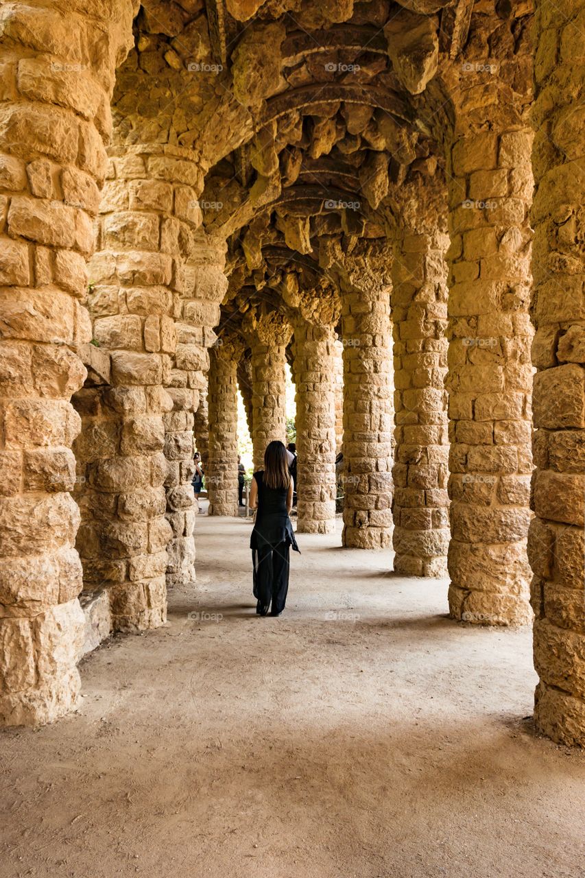 Rear view of a woman standing in arch corridor
