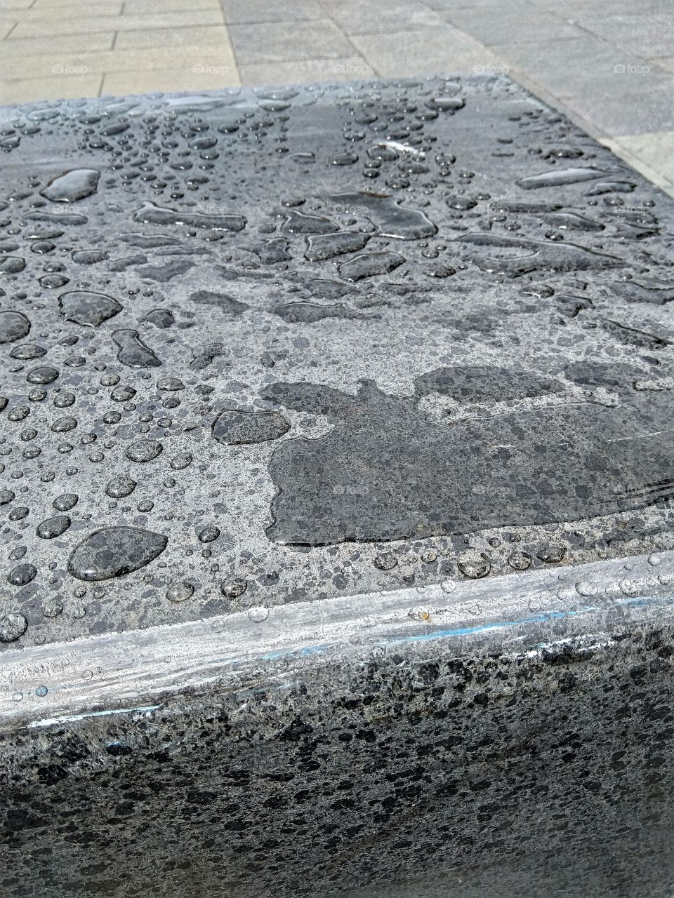 water droplets on a slab next to some chairs