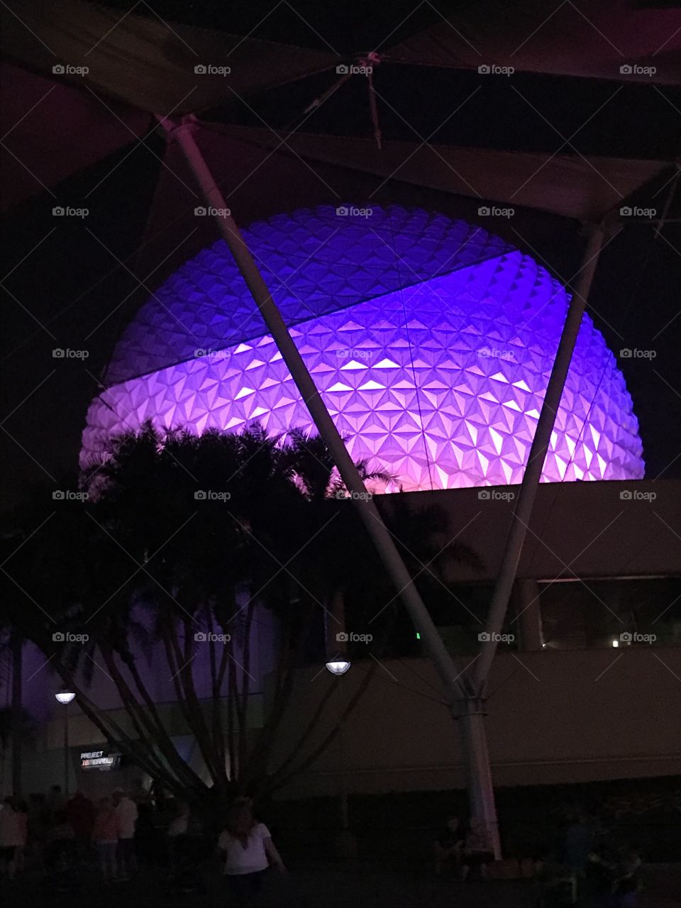 This picture shows the Epcot ball at Walt Disney World. It is illuminated with colorful lights so it can still be seen at night.