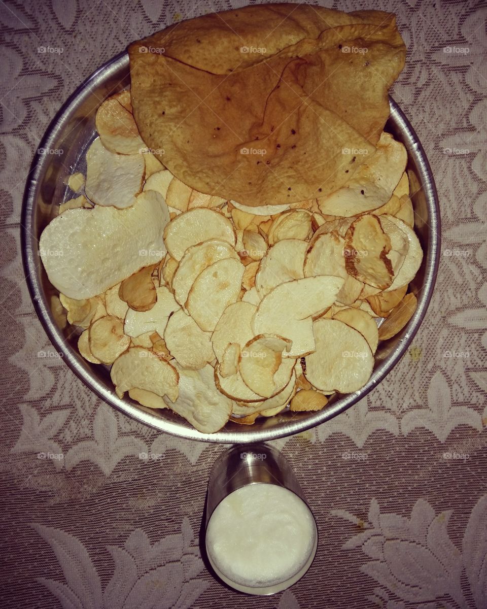 Homemade potato chips with papad and lassie