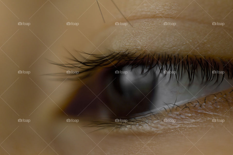 macro close up of deep black eye almond shape of a young Asian boy