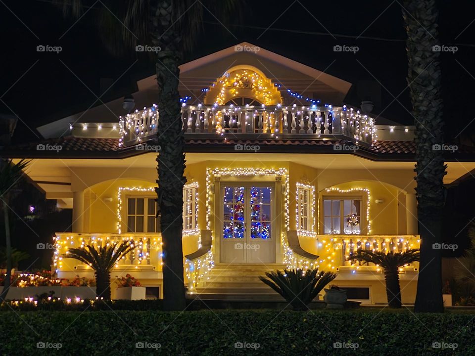 night photo of house decorated with Christmas lights