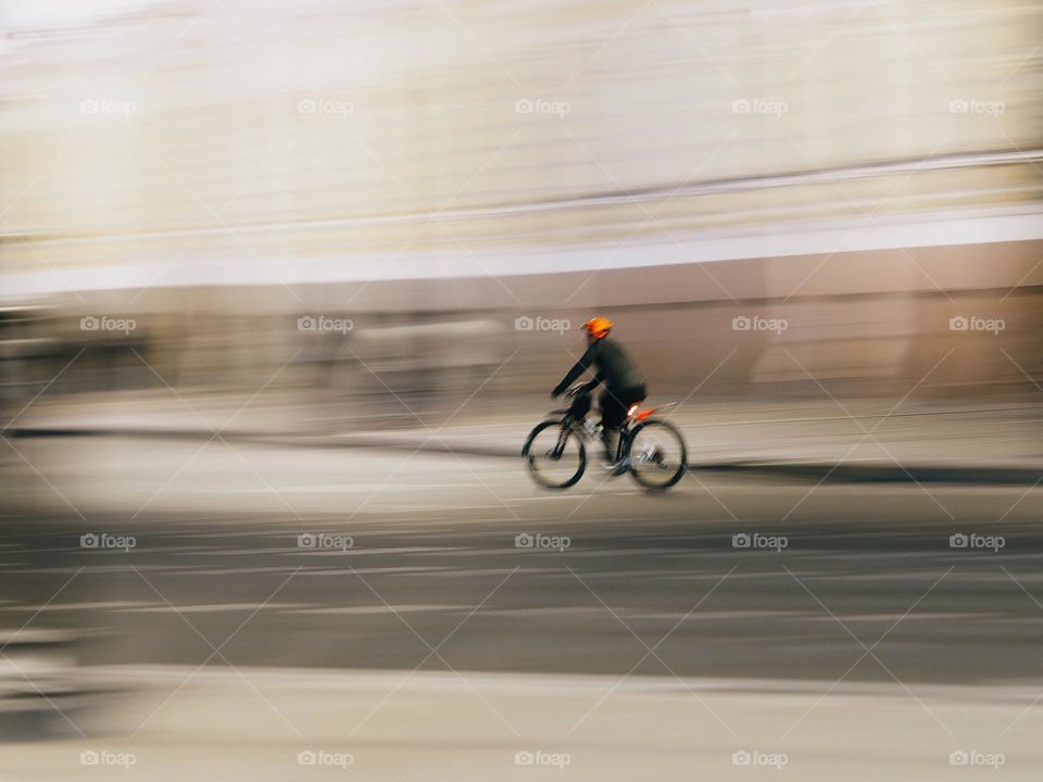 Men on a bicycle riding on night street, long exposure 