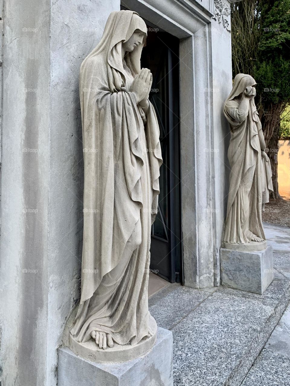 Entrance of the sepulchral mausoleum of Alessandro Volta in Camnago Volta, near the city of Como, two beautiful sandstone statues represent science and religion.