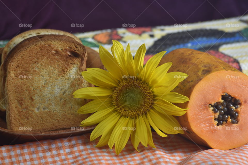 Pão torrado, mamão e girassol/Roasted bread, papaya and sunflower.