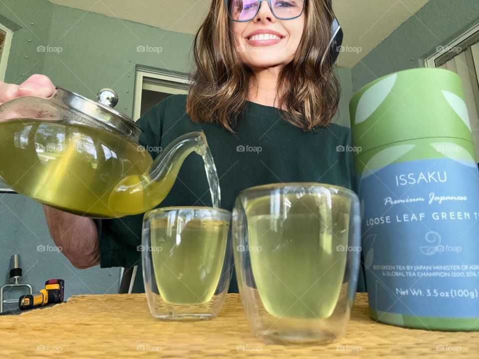 Woman pouring green Japanese tea.