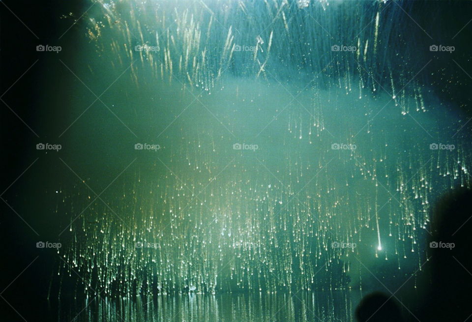 Fireworks display above a lake, with reflections