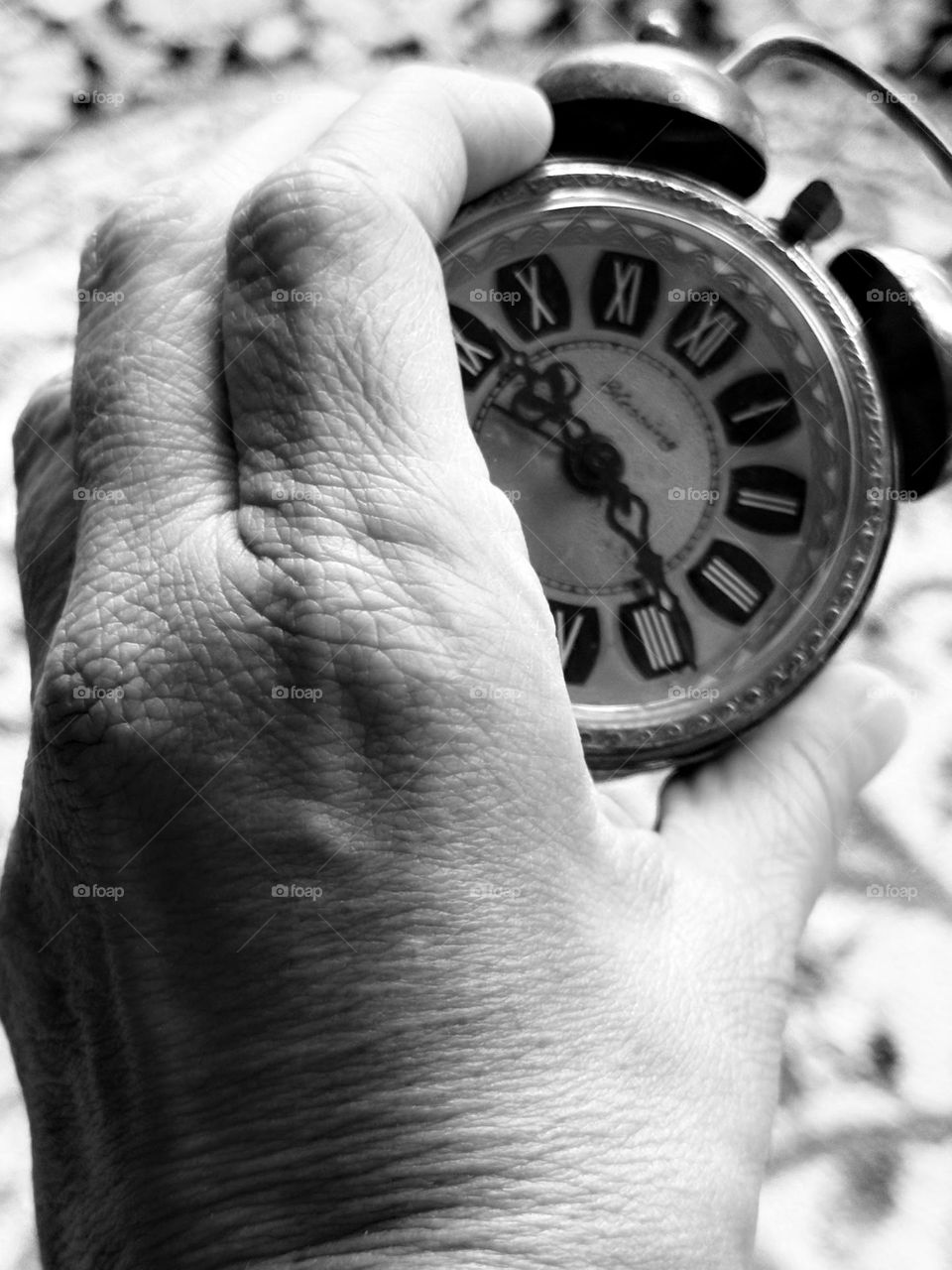 Hand holding vintage double bell clock when time stands still