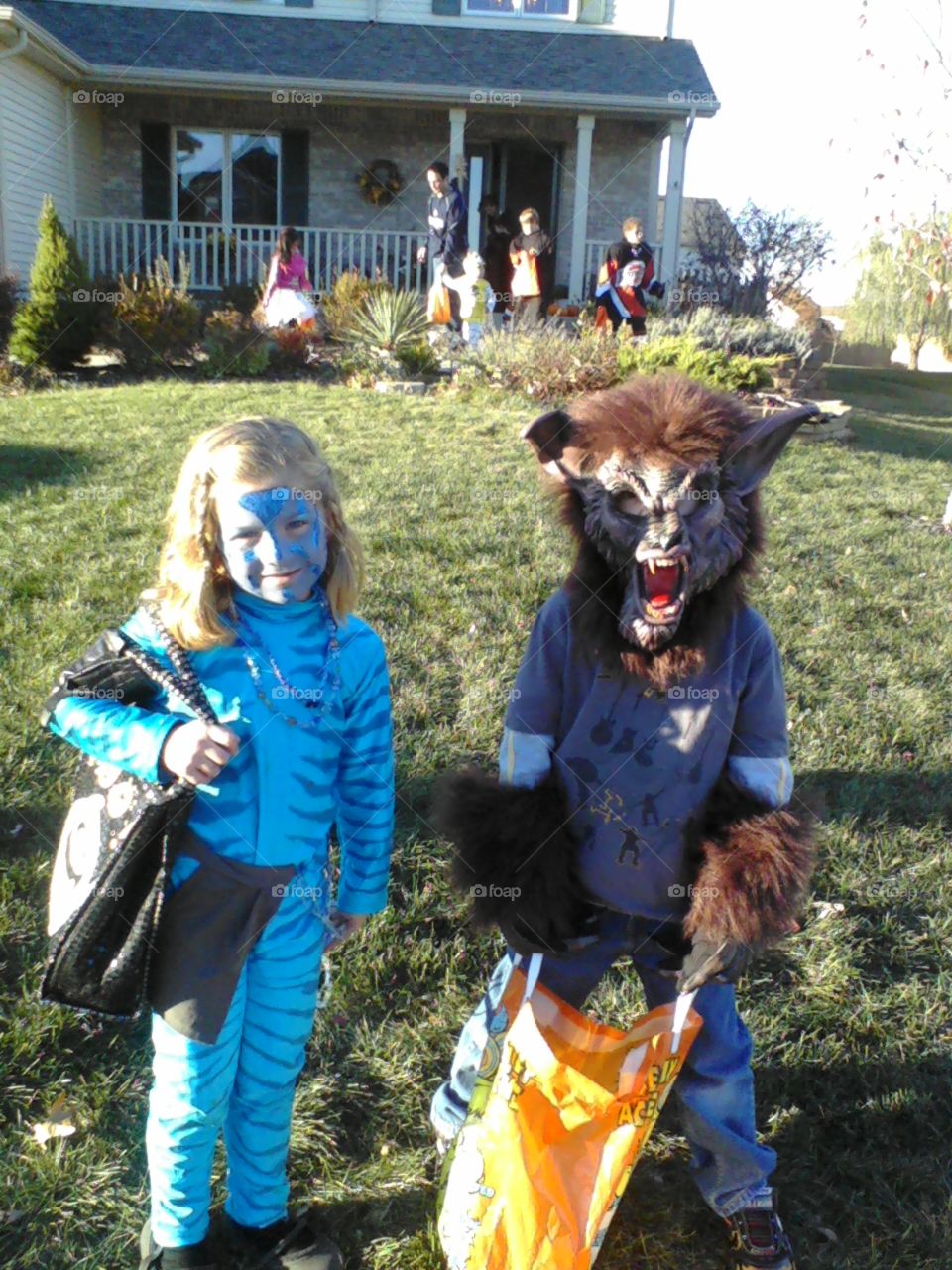 Two children trick-o-treating on Halloween.