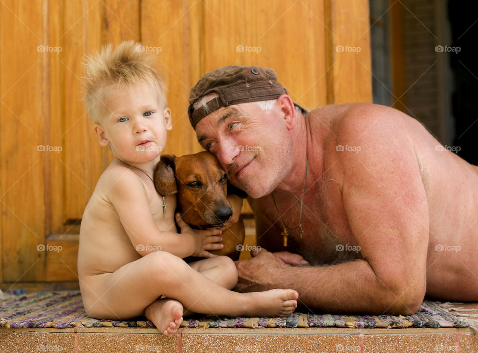 grandfather, grandson and their dog spend time together at the dacha