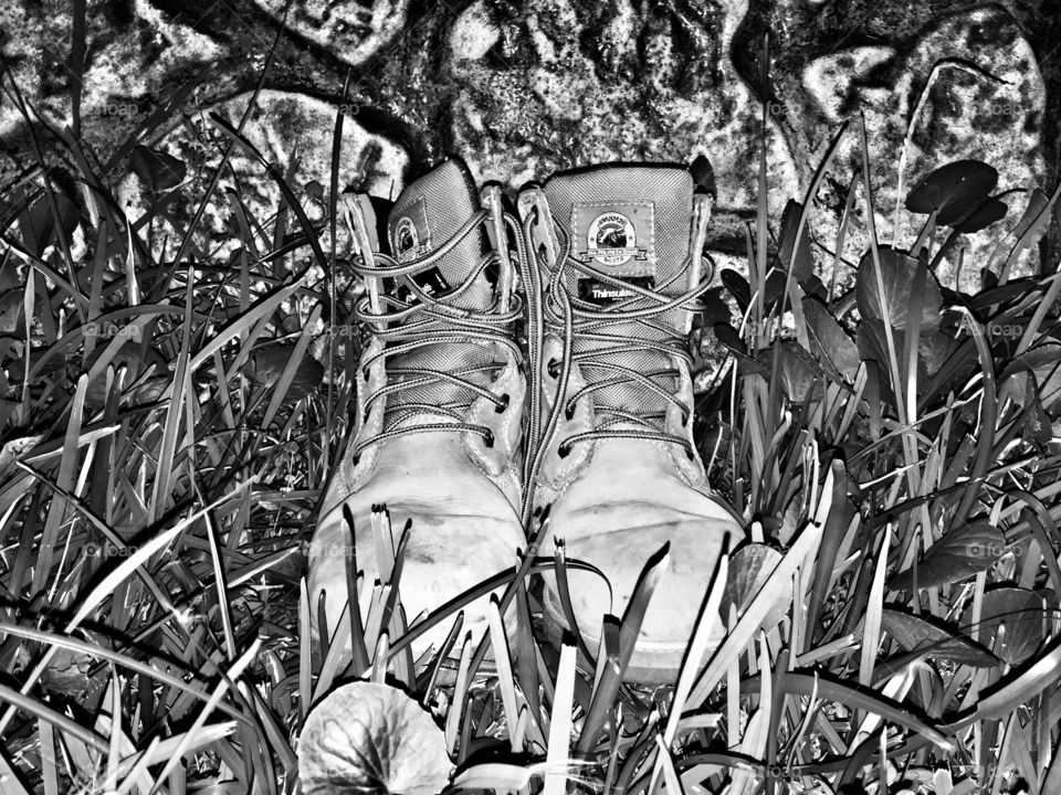 Black and white picture of hiking boots in the grass