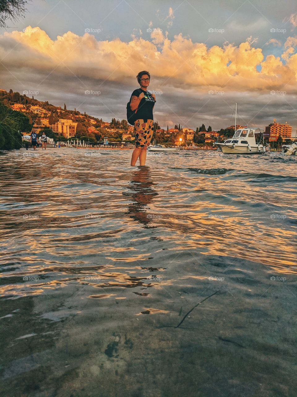 Happy woman walking at the adriatic seaside at the sunset.