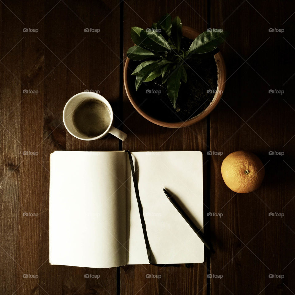 Oranges, coffee and notebook. Still life with a notebook, cup of coffee and oranges